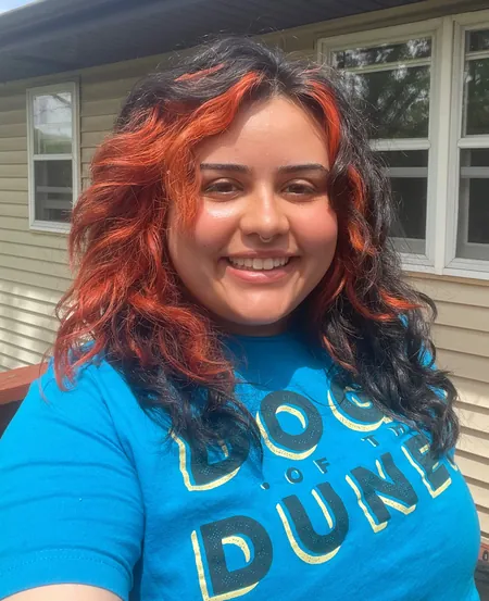 Scarlet Cisneros is smiling wearing a blue Dogs of the Dunes shirt. Scarlet is an expert in dog training, dog walking, and dog boarding. She is ready to tackle behavioral issues in dogs and resolve them quickly, leaving lasting results.