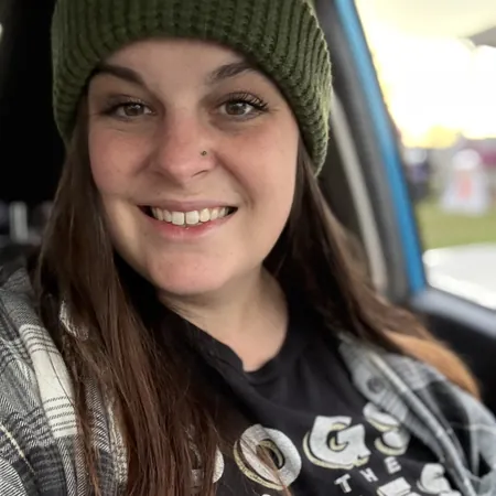 Cadie Davis-Stover is wearing a black Dogs of the Dunes shirt and smiling widely at the camera. Her dog training expertise is apparent and she is ready to tackle your dog training needs.