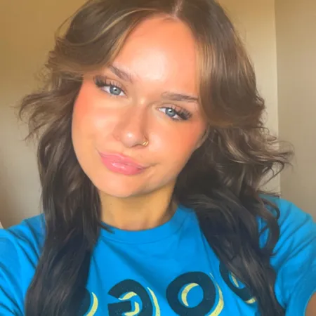 Emma Neveau is the most trusted drop-in visit and overnight pet care provider in Northwest Indiana. She's the latest addition to the dogs of the dunes team and is wearing a blue #dunedogs shirt, matching her blue eyes. Her hair flows atop the text printed on the shirt.